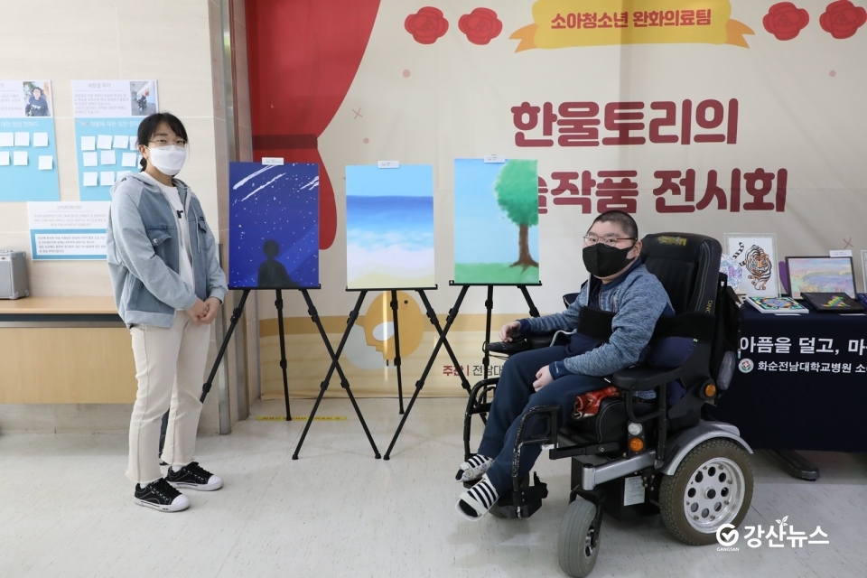 근이영양증으로 투병 중인 최한결씨와 어머니 조나영씨가 지난해 11월 전남대학교어린이병원 1층에서 미술작품 전시회를 열고 기념사진을 촬영하고 있다.